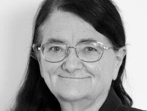 a black and white photo of Professor Sara Chandler KC (Hon) wearing glasses and smart business attire.