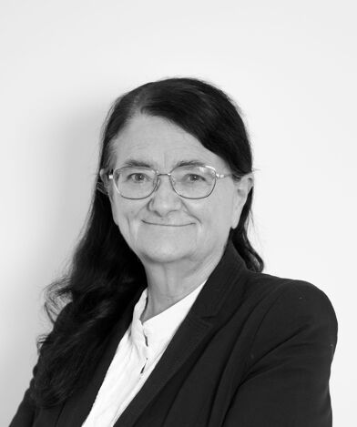 a black and white photo of Professor Sara Chandler KC (Hon) wearing glasses and smart business attire.