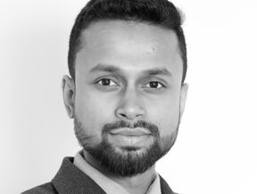 A black and white photo of Aman Ali in a business suit.
